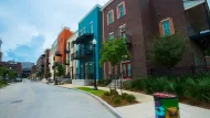 Row of multicolored three-story apartment buildings.